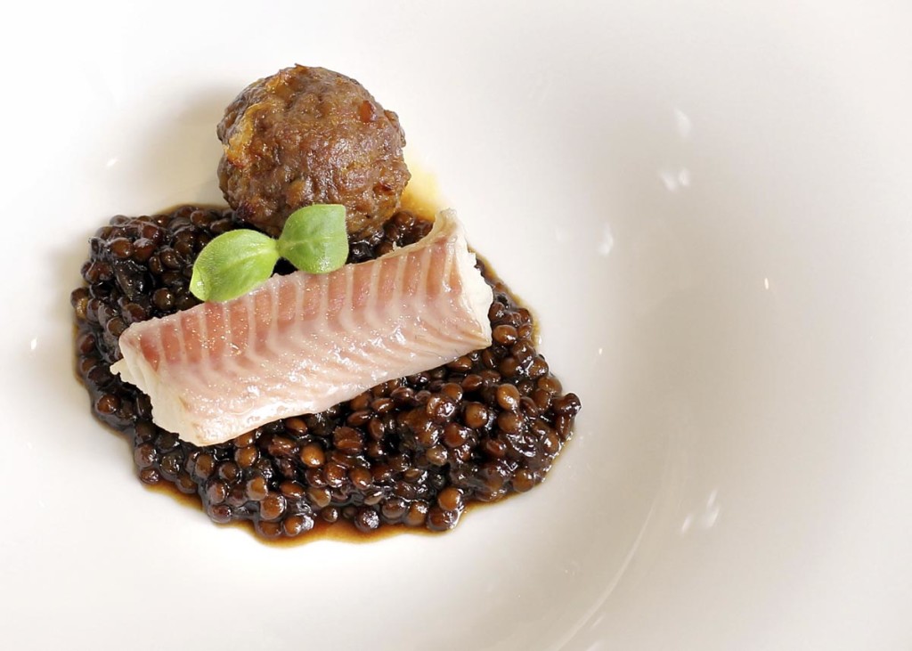 Anguila aumada y lentejas caviar en guiso con albondiguita a la naranja